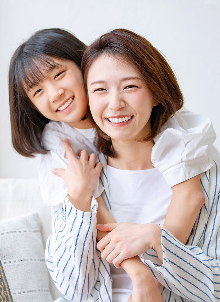 母親と子どもが笑顔で寄り添う様子（子どものメンタルヘルスサポートのイメージ）