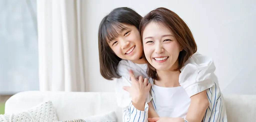 母親と子どもが笑顔で寄り添う様子（子どものメンタルヘルスサポートのイメージ）